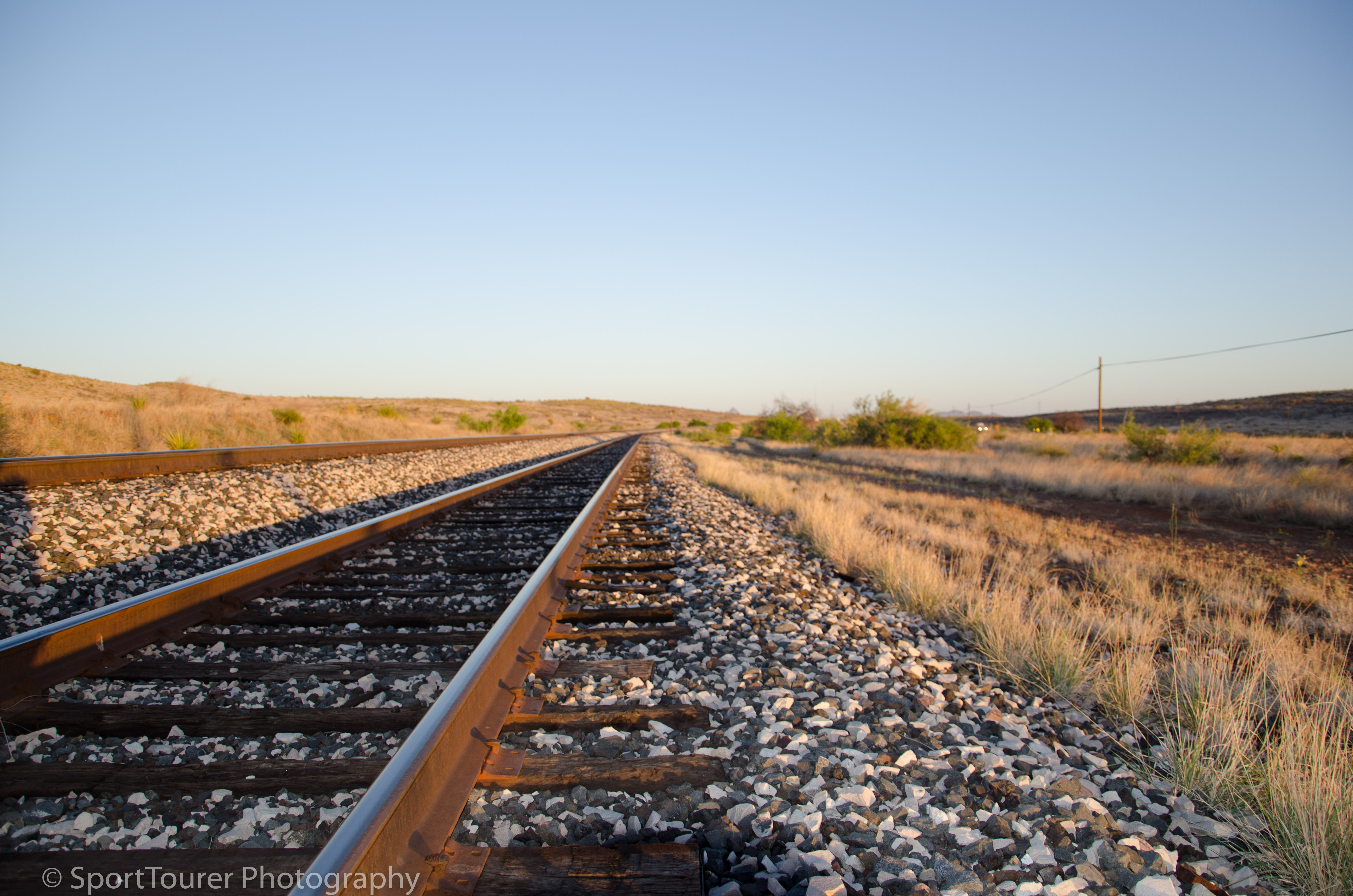  On a beautiful Texan morning at sunrise, the railroad tracks, just like the roads, continue to run straight and true as far as your eyes can see. 